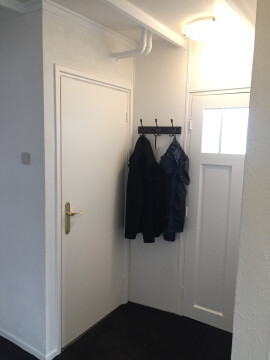 Grote hal met bergkast en kapstok