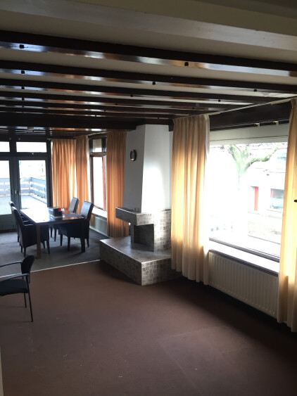 Woonkamer met veel lichtinval, openslaande tuindeuren naar dakterras